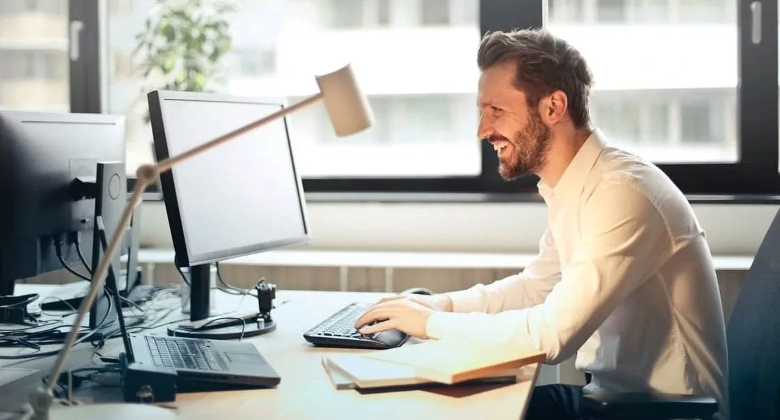 Ein Mann arbeitet im Sitzen am Schreibtisch in einem Büro