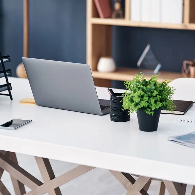 Picture-2 Ein minimalistisch gestaltetes Heimbüro mit einem Laptop auf einem weißen Tisch