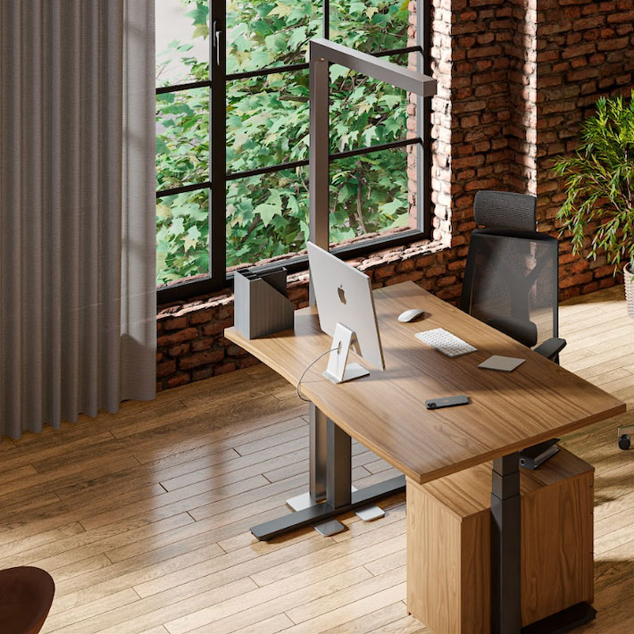 Ein Einzelbüro mit Blick auf Bäume, ausgestattet mit einem ergonomischen Stuhl, einem Schreibtisch mit Laptop, Monitor und Bürozubehör, kombiniert Gemütlichkeit mit Funktionalität.