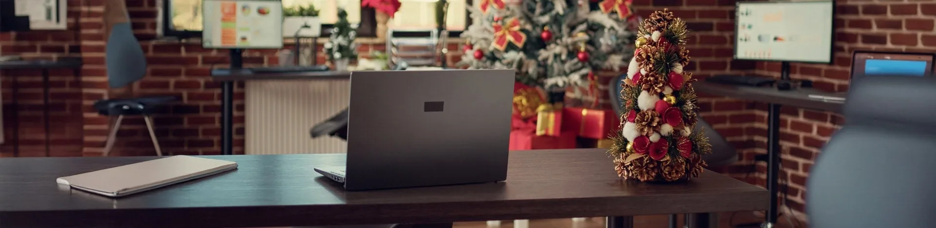 Weihnachtsdeko im modernen Büro – geschmückter Tisch mit Mini-Weihnachtsbaum und festlicher Atmosphäre